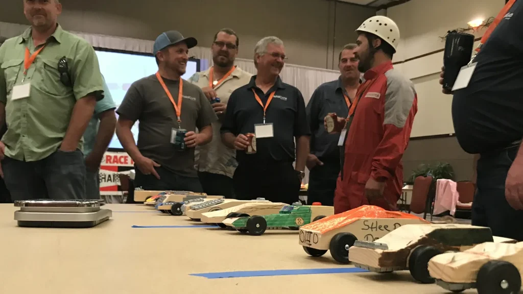 Teams display their handcrafted pinewood-style race cars during Venture Up's Mega Car team-building event.