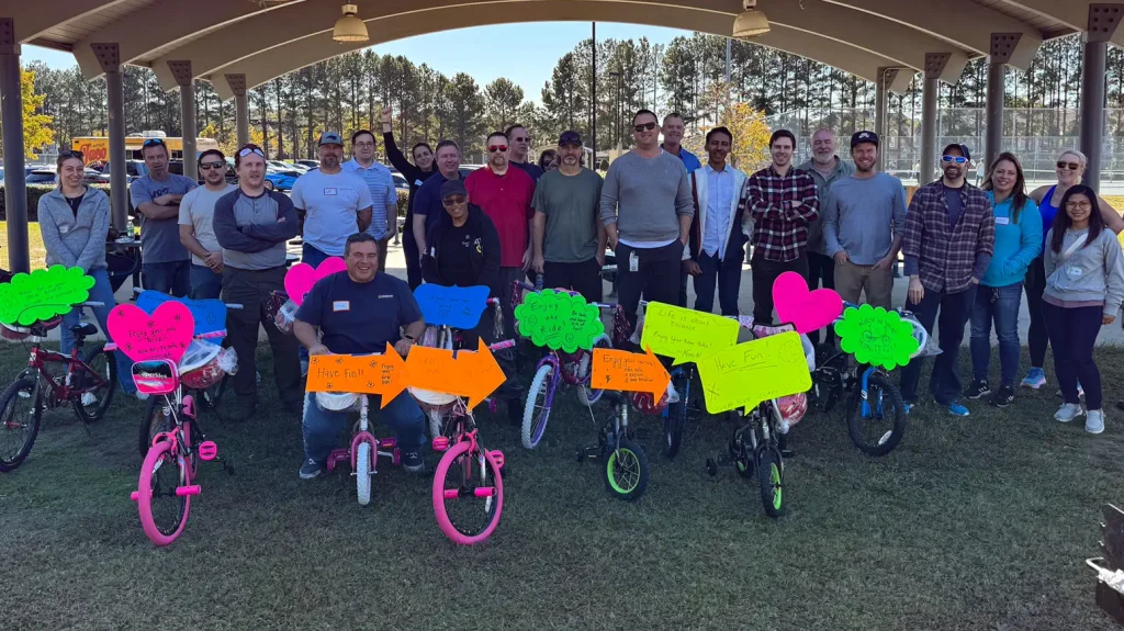 Corporate team posing with charity bikes during Bike Building in Clayton