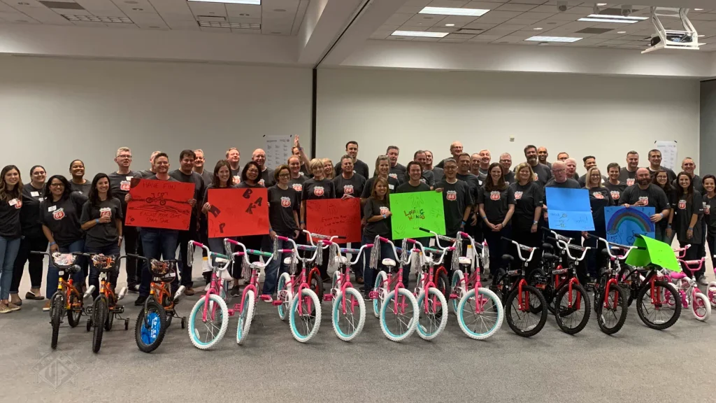 Large team posing with completed bikes during Bike Building in Houston