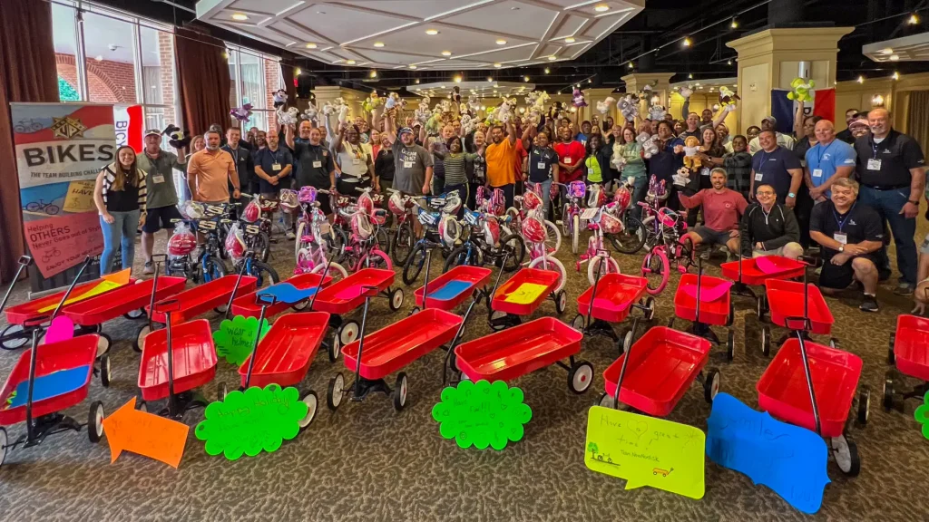 Group posing with Bike Building and Wagon build donations in Pinehurst