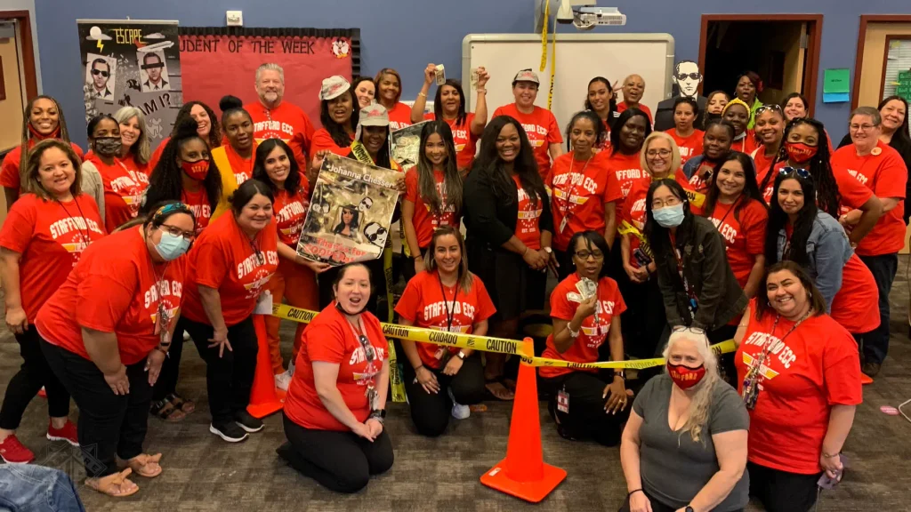 Stafford team celebrating Escape Case with clues and caution tape