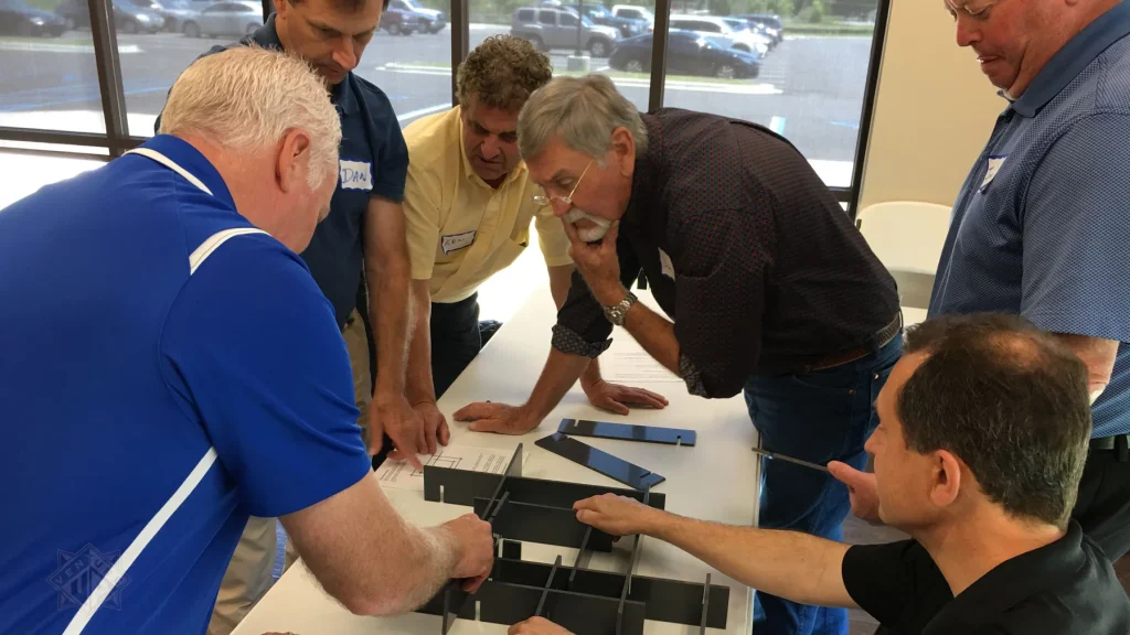 Team members assemble a maze structure during Venture Up's Project 15: The Maze team-building activity.