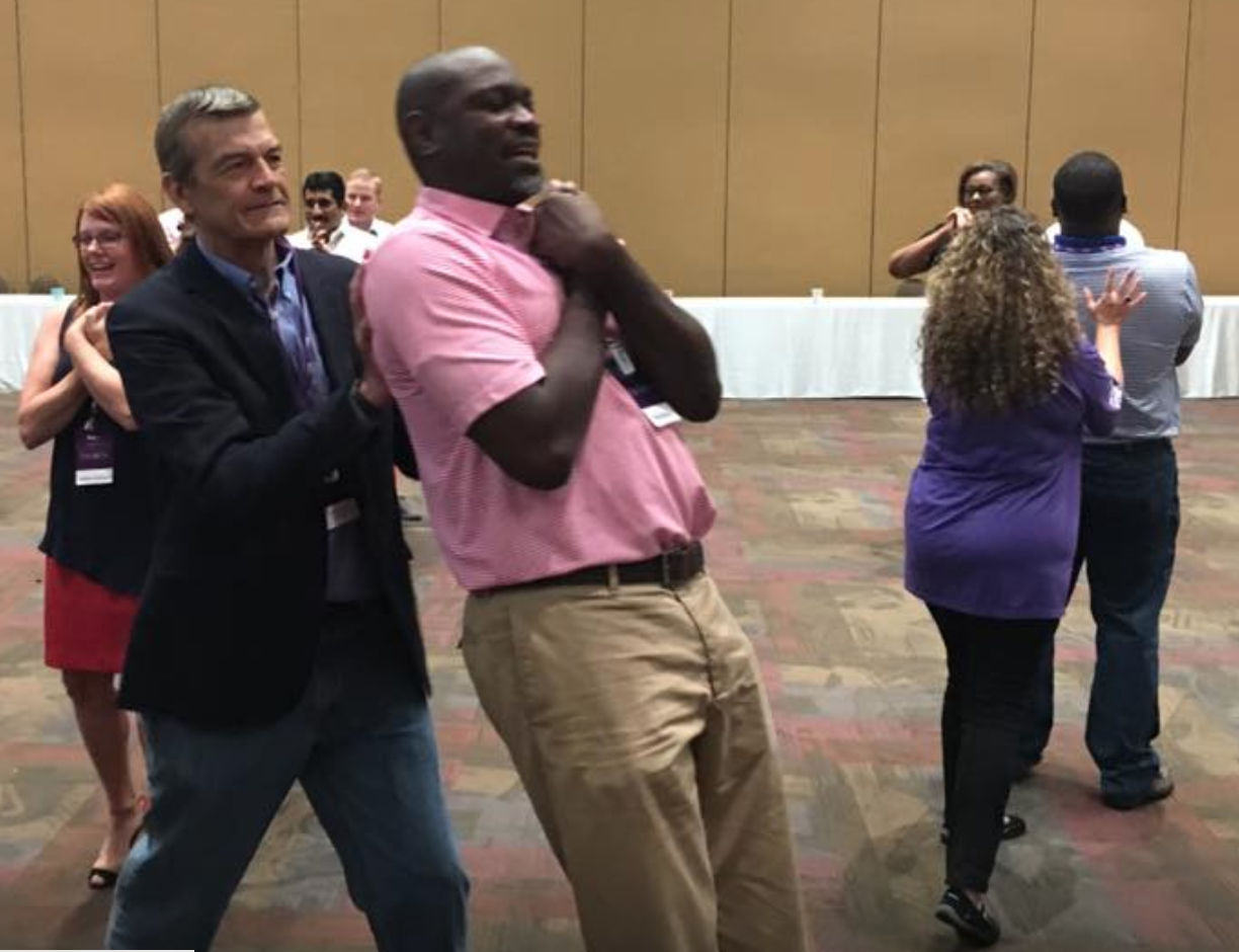 Corporate executives engage in indoor strategic games including the famous trust fall, a top choice team activity since Venture Up began in 1983.